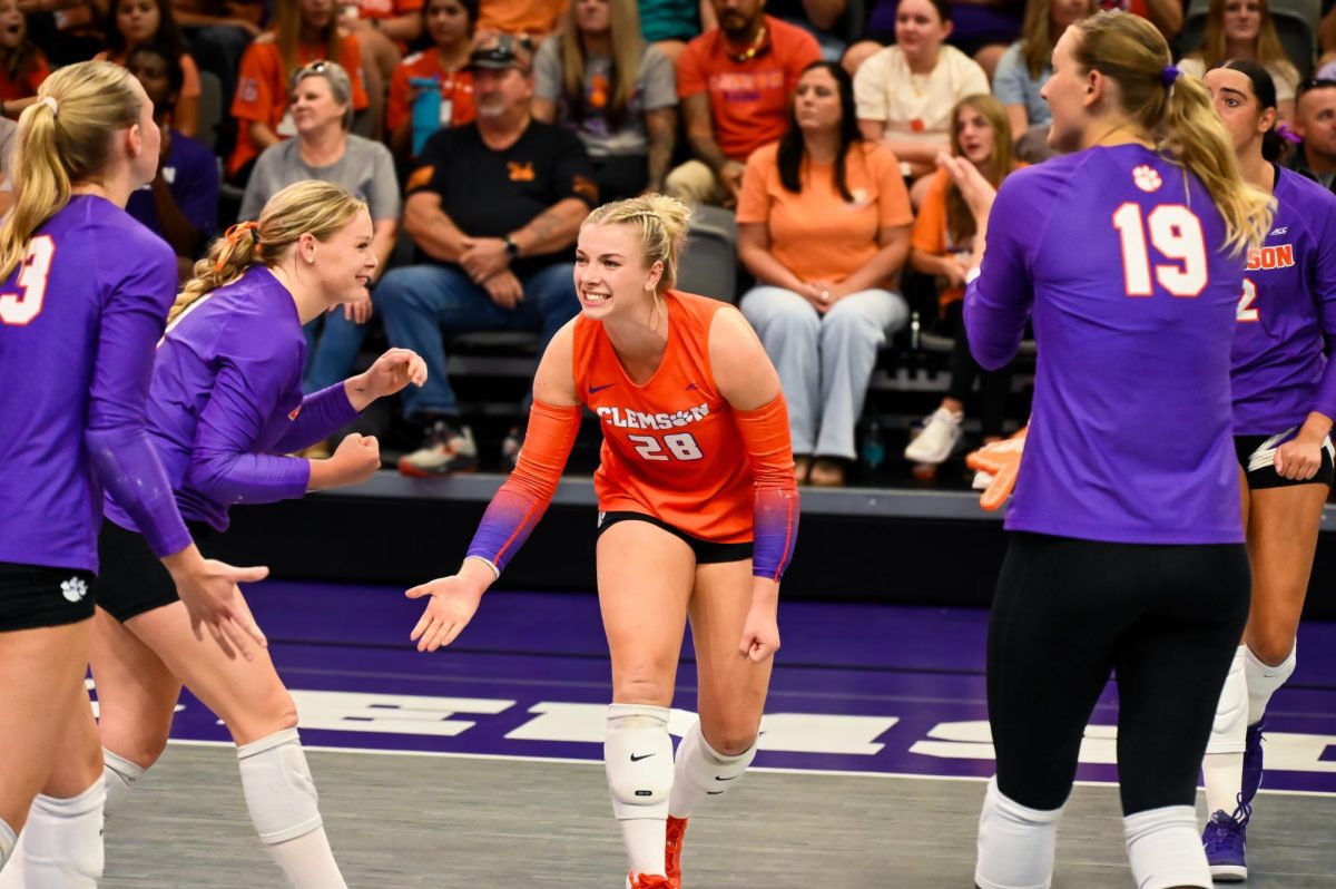 Clemson libero Mckenna Gildon high-fives her teammates after winning a gritty point against Miami.