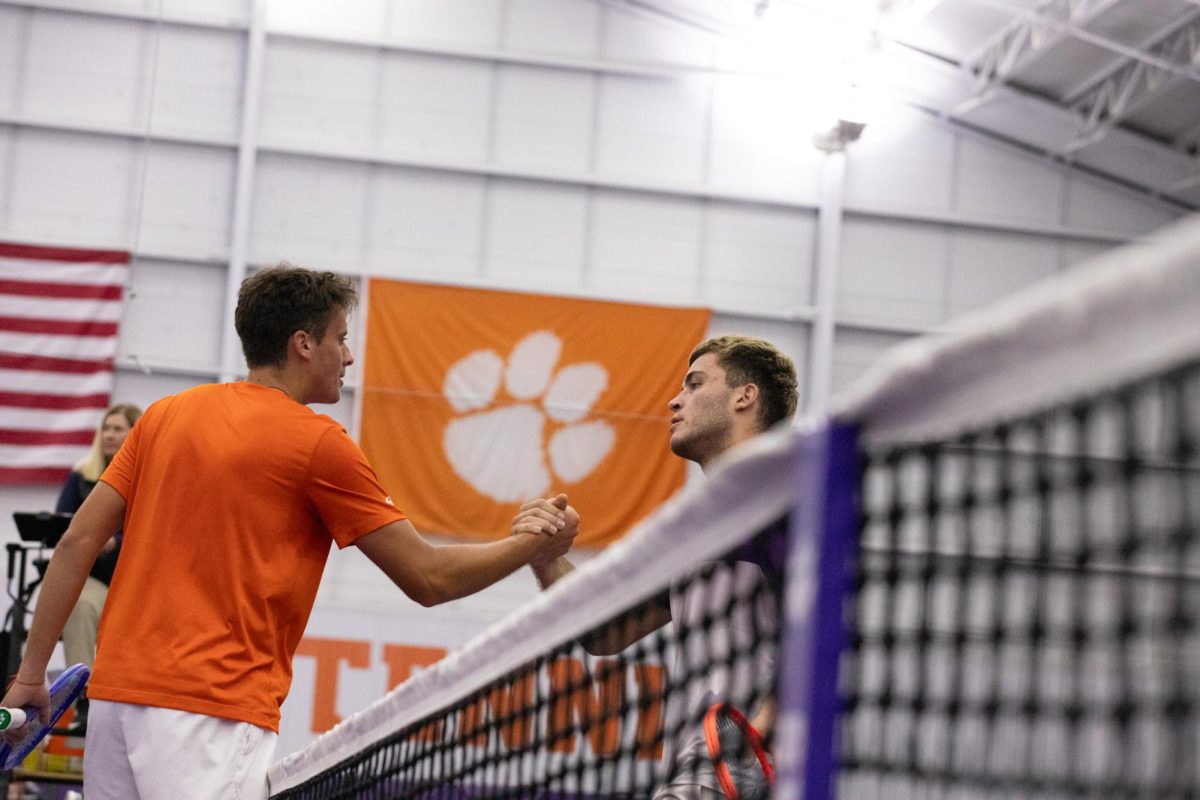 Viktor Markov meets his opponent at the net for a post-match handshake.