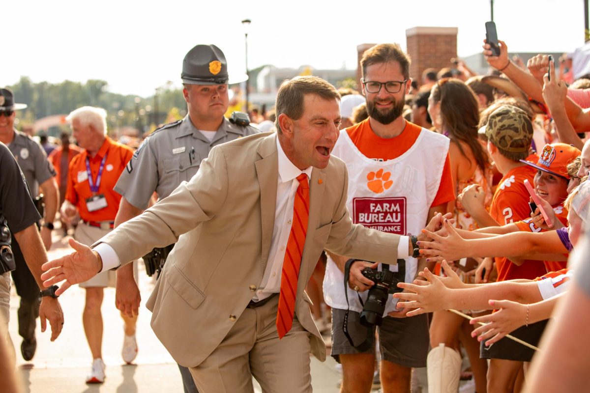 Clemson head coach Dabo Swinney high-fives fans at Tiger Walk ahead of a matchup against LSU on Aug. 30, 2025. 